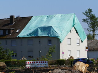 May 2022 a tornado caused severe damage in Lippstadt, North Rhine-Westphalia, Germany, here a makeshift tarpaulin lies on a roof - obrazy, fototapety, plakaty