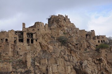 Fototapeta na wymiar Ruins of abandoned ghost village Gamsutl at top of mountain peak in Dagestan, North Caucasus, Russia