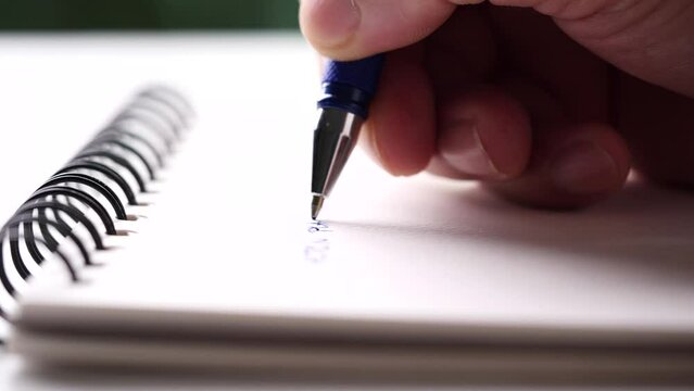 Close up hand writing paper on notebook with blue pen to note, memo, list action plan at office or home desk, selective focus 4k resolution. Concept of writing paper, letter, pen, notepad, diary