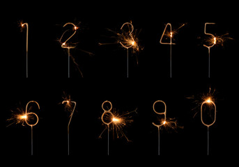 Golden sparklers in numbers digits shape set, bengal fire burning bright with sparks, isolated on black background - 523599842