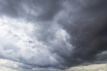 The dark sky with heavy clouds converging and a violent storm before the rain.Bad or moody weather...