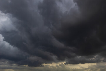 The dark sky with heavy clouds converging and a violent storm before the rain.Bad or moody weather sky and environment. carbon dioxide emissions, greenhouse effect, global warming, climate change.