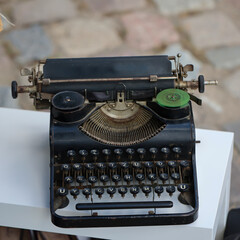 Auf einem Tisch im Freien steht eine alte nostalgische Schreibmaschine.