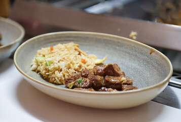 Rindfleisch mit Reis auf einem Teller.
