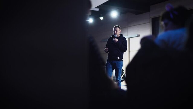 Conference in the IT industry. A young and successful male speaker talks about modern solutions to students and colleagues.