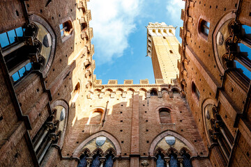 Fototapeta premium Interior courtyard and tower of the city hall (in italian: Palazzo Comunale or Palazzo Pubblico) in Siena, Tuscany, Italy, Europe