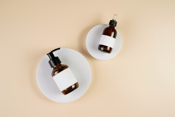 mock-up of brown cosmetics bottle with dispenser and white label, bottle with pipette on white...