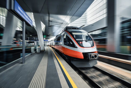 High speed train in motion on the railway station at sunset