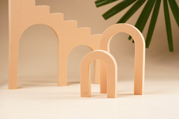 Peach colored arched doors and arches - props for product photography on beige colored background
