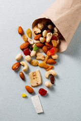 A handful of dried fruits and nuts in a paper bag