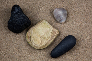 Fototapeta na wymiar Stones and Small Rocks on a Sandy Coastal Beach