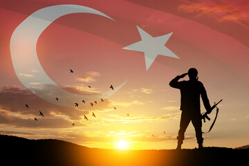 Silhouette of soldier on a background of Turkey flag and the sunset or the sunrise. Concept of crisis of war and conflicts between nations. Greeting card for Turkish Armed Forces Day, Victory Day.