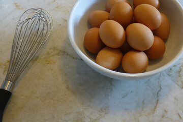 a dozen brown eggs in a white bowl