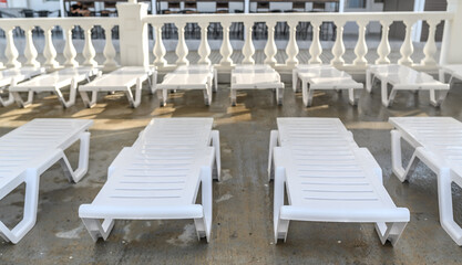 White deck chairs on the coast of the sea and the beach. Rest and relaxation on vacation.