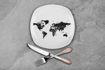 A shape world map on a plate. Fork and knife on a background. Abstract Concept of global hunger.