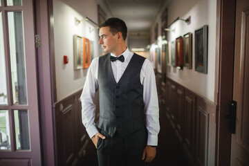 Fototapeta premium groom at wedding tuxedo smiling and waiting for bride. Rich groom at wedding day. Elegant groom in costume and bow-tie.