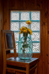 Ripe sunflower in a glass jar in front of the window