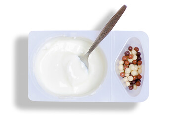 Plastic cup yogurt with chocolate balls and spoon on white background isolation