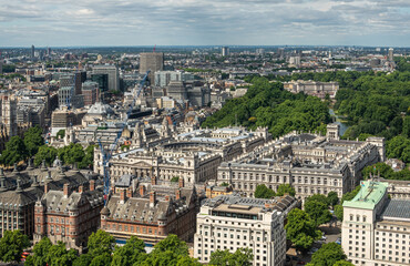 Fototapeta na wymiar London, UK - July 4, 2022: Seen from London Eye. Imperial War Museum square buildings with green St. James's park behind set in dense urban jungle cityscape under blue cloudscape.