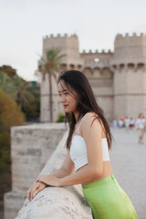 Fototapeta premium Beautiful young Asian woman walking the street of historic European town. Female tourist from China traveling in Europe, smiling. Exchange student. 