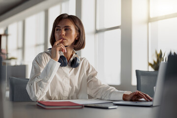 Attractive european business woman working laptop while sitting in cozy cafe. Blurred background