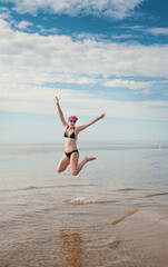 Happy funny woman jumping in the water of sea
