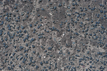 Perfect black asphalt interspersed with large gravel close-up. Texture of black asphalt in England