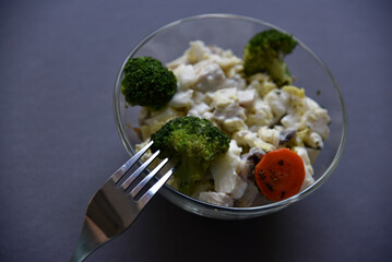 Salads with mayonnaise and vegetables with meat in glass salad bowls on a black background. Delicious salads with forks on a black background. Salads with a still life.