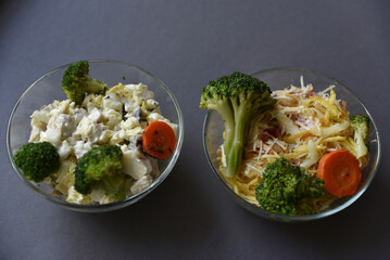 Salads with mayonnaise and vegetables with meat in glass salad bowls on a black background. Delicious salads with forks on a black background. Salads with a still life.