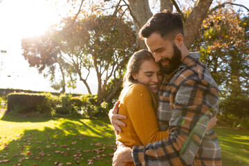 Fototapeta premium Image of happy caucasian couple hugging in autumn garden