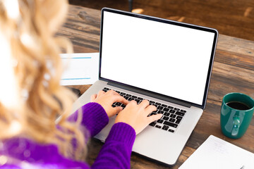 Fototapeta premium Over shoulder view of caucasian woman using laptop on coffee table working at home