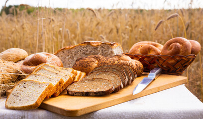 lot of different flavored bread, wheat, rye, on the table in the field outside