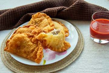 deep-fried golden chebureks or dumplings are laid out on a plate