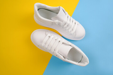Casual comfortable white shoes.Stylish women's leather shoes with laces on a yellow-blue background. Seasonal sales, promotions, discounts on shoes. Proper care for white skin.View from above.