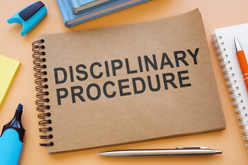 Notebook about disciplinary procedure with papers on the table. - obrazy, fototapety, plakaty