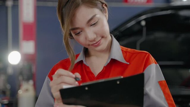 Close-up parallax, female receptionist in a service station or garage checking a list of maintenance documents.Service station concept, maintenance, and road accident reduction