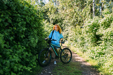 Obraz premium A young woman uses a modern electric bicycle for sports and outdoor recreation 