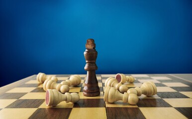 Shiny chess figures standing on wooden chessboard. Intellectual duel and tactical battle symbol....