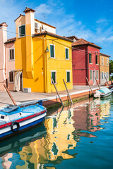 Fototapeta na wymiar Yellow and red houses on the canal in Burano island, Venice, Italy.