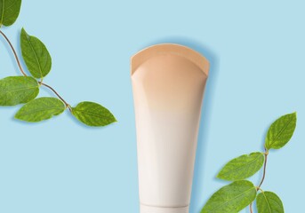 White Cream tube and branches with young small leaves. Cosmetic skincare product blank plastic package. White bottle of unbranded lotion, balsam, toothpaste mockup