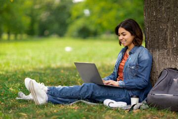 E-learning Concept. Arab Female Student With Laptop Sitting Under Tree In Park