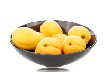 Naklejka na ściany i meble Several bright yellow juicy pineapple apricots in a pottery, macro, isolated on a white background.