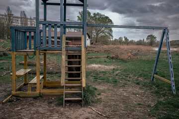 An old abandoned playground among felled trees