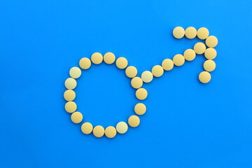Male sign lined with yellow pills on a blue background.