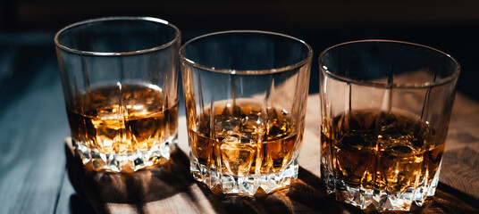 Whiskey glass on wooden background