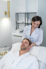 Dark-haired professional doing face massage to a male customer