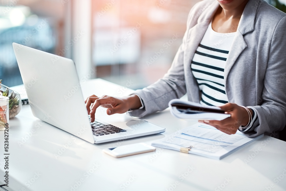 Poster business woman typing on laptop, reading from notebook and planning a strategy in an office at work.