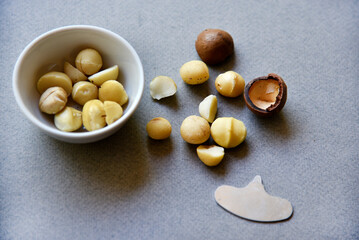 Delicious peeled Macadamia nut in a salad bowl on a gray background. The kernels of a delicious Macadamia nut close-up.