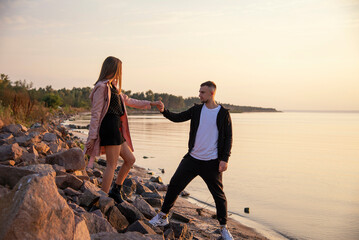 Fototapeta premium young beautiful couple walking on the beach on sunset