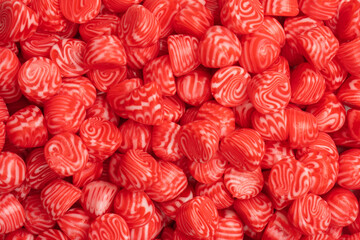 Red round tasty gummy candies as a background.